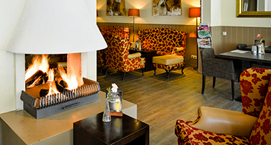 Loungeruimte met open haard van Fletcher Hotel-Restaurant Victoria-Hoenderloo